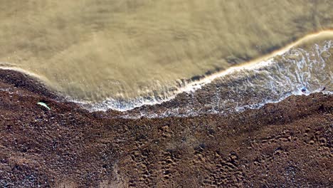 Murky-sea-water-waves-hitting-the-pebble-beach-on-the-Kent-coast-of-Herne-Bay-in-UK