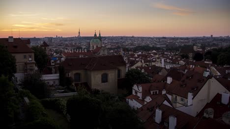 Timelapse-of-sunrise-over-the-roofs-of-Malá-Strana-in-Prague,-Czech-Republic-as-seen-from-Hradčany-near-Prague-Castle-as-the-sun-slowly-illuminates-the-famous-red-roofs