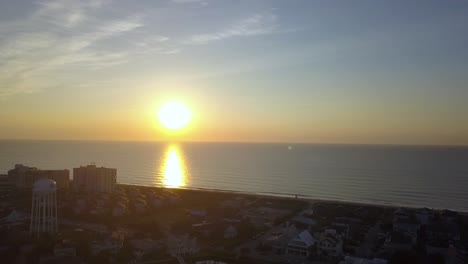 Entspannender-Sonnenaufgangs-Überflug-über-Hotel-Und-Wasserturm-Am-Shell-Island-Wrightsville-Beach,-North-Carolina