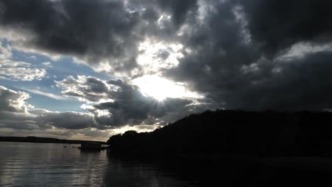 4.000-Horas-De-Puesta-De-Sol-Sobre-El-Lago-Y-Una-Pequeña-Montaña-Con-Múltiples-Nubes-En-El-Cielo-Azul