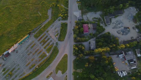 Aerial-view-overlooking-cars-on-road-Р05,-in-Shepetivka-village,-during-sunset,-in-Ukraine---tilt-up,-drone-shot