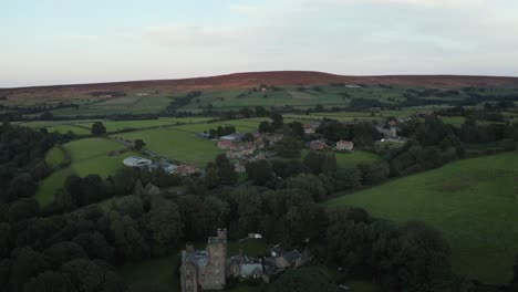 Eine-Drohne-Aus-Geringer-Höhe-Zeigt-Kurz-Nach-Sonnenuntergang-Eine-Aufnahme-Des-Dorfes-Westerdale-Und-Der-Westerdale-Hall