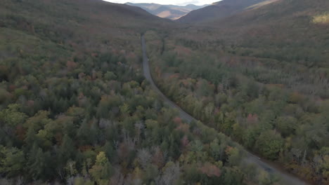 Vista-Aérea-Lenta-De-Una-Carretera-Vacía-De-New-Hampshire-Con-Follaje-Otoñal