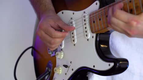 close-up-detail-of-the-musician's-hands-playing-his-electric-guitar