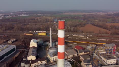 Luftaufnahme-Eines-Industriegebiets-Mit-Einem-Schornstein-Und-Einem-Zug-Im-Hintergrund