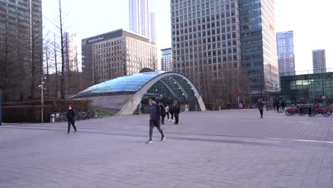 People-wearing-face-masks-crossing-Reuters-Plaza-at-Canary-Wharf,-London