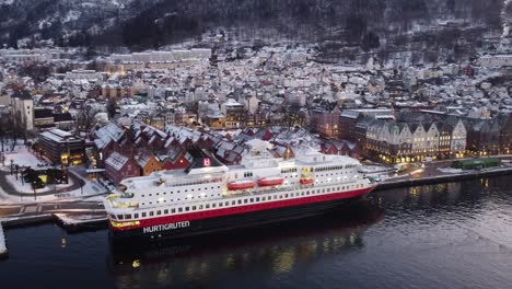 Luftaufnahme-über-Dem-Hurtigruten-Kreuzfahrtschiff-Im-Hafen-Von-Bergen,-Hintergrund-Der-Winterstadtszene