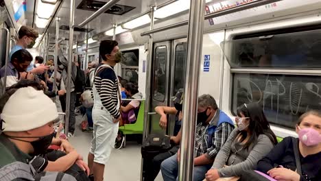 Subway-car-during-“the-new-normal”-post-covid-19-in-Mexico-City,-people-wearing-face-mask-in-subway