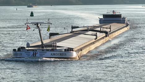 Cargo-ship-Amoureus-travels-on-calm-water-in-Netherlands,-close-aerial-pan