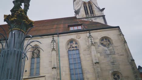 Ciudad-Histórica-De-Tubinga,-Alemania-|-Multitudes-Cerca-De-Una-Gran-Estatua-Y-La-Catedral