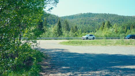 Vehículos-Que-Circulan-Por-Una-Carretera-Rural-A-Plena-Luz-Del-Día-En-Hesttjønna,-Indre-Fosen,-Trøndelag,-Noruega---Toma-Manual