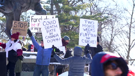 Kanadier-Protestieren-In-Toronto-Gegen-Die-Covid-19-Maßnahmen,-Menschen-Halten-Schilder-Hoch