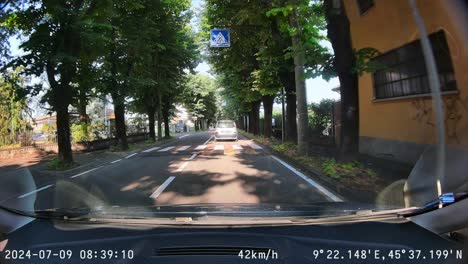 POV-dash-cam-footage-for-sunny-day-drive-through-Vimercate,-Italy-streets