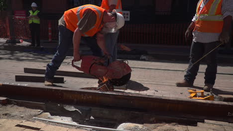 Construction-workers-cuts-steel-for-the-new-railroad-tracks-with-a-large-saw