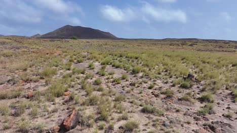 Volando-Sobre-Campos-De-Lava-Con-Un-Volcán-Inactivo-Al-Fondo