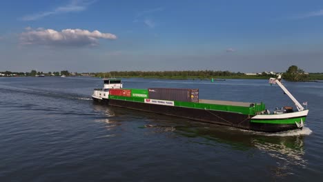 Wide-aerial-side-view-of-cargo-ship-Tornado-on-river-in-Netherlands