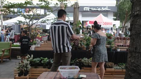 Asian-guy-explaining-lady-that-is-looking-for-some-plants-to-buy-in-the-store