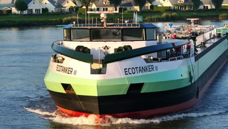 Close-frontal-aerial-of-LNG-fueled-tanker-ship-Ecotanker-III-on-Dutch-river,-golden-hour