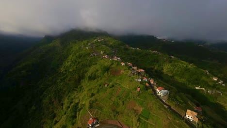 Winding-road-curves-up-hillside-to-ridge-past-cozy-homes-with-red-roofs