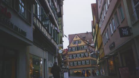 Ciudad-Histórica-De-Tubinga,-Alemania-|-Banderas-De-Celebración-Colgando-Sobre-Tiendas-Coloridas