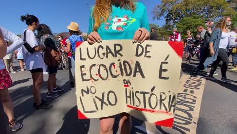 Eine-Frau-Hält-Ein-Schild-Mit-Der-Aufschrift-„Ökozid-Gehört-In-Den-Müll-Der-Geschichte“-Bei-Der-Protestaktion-Gegen-Die-Tötung-Zweier-Männer-Im-Amazonasgebiet.