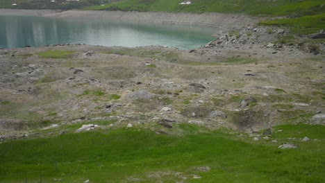 Clear-blue-alpine-lake-surrounded-by-snowy-mountains,-Mont-Cenis,-France