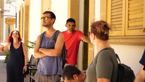 Group-Of-Friends-Outside-Cafe-Waiting-Around-On-Sunny-Bright-Day-In-Nicosia