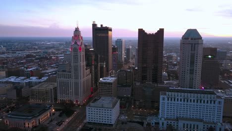 Aerial-drone-view-towards-the-skyline-of-Columbus,-with-purple-evening-sky-background