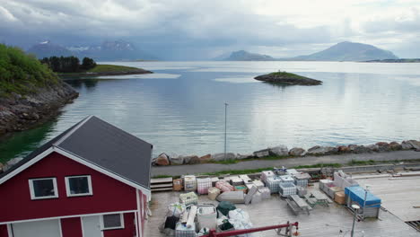 Aerial-Forwarding-shot-of-Fishing-Vessels-at-Tonnes-Harbor-on-a-calm-day-with-dramatic-sky-in-Norway