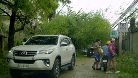 Car-and-scooter-on-dirt-road-after-Typhoon-Rai-in-the-Philippines