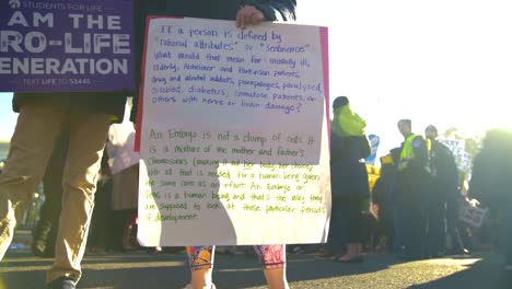 Two-people-showing-off-their-signs-at-a-rally-outside-the-Supreme-Court-building