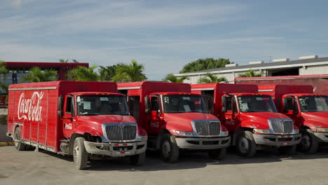 Row-Of-Parked-Coca-Cola-Trucks-At-Distribution-Centre-In-Punta-Cana,-Dominican-Republic