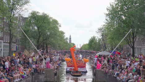 Dutch-boat-with-lgbtq-supporters-carrying-rainbow-flags-during-Pride-parade-in-Amsterdam,-Netherlands-during-Pride-week