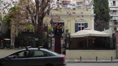 car-and-people-passing-in-front-of-a-cafeteria-in-the-city