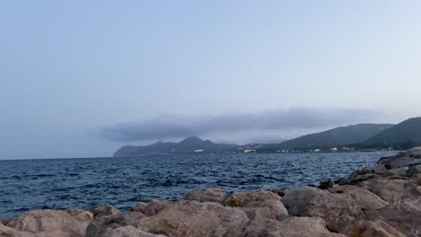 Felsküste-Mit-Malerischer-Aussicht-Auf-Das-Meer-Und-Die-Berge-Unter-Klarem-Himmel