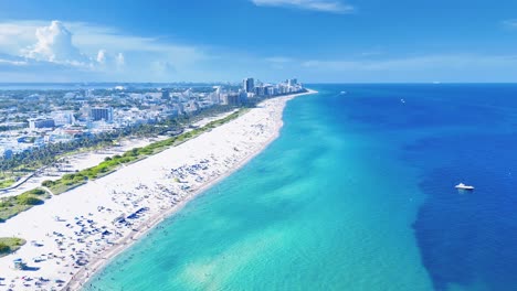 Eine-Drohne-Fliegt-Hoch-Und-Präsentiert-Die-Weite-Landschaft-Mit-Klarem-Ozean,-Blauem-Wasser,-Sandstrand,-Miami-Beach-City-Und-Hohen-Gebäuden