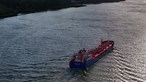 Aerial-Ascending-Over-Cargo-Ship-on-River-Revealing-Expansive-Waterway,-Establishing-Western-European-Rural-Area