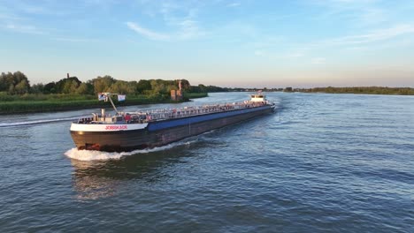 Slow-Largo-Cargo-Ship-Getting-Overtaken-by-Speedboat-on-River