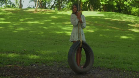 Una-Joven-Con-Rizos-Se-Deleita-En-Un-Día-Soleado-En-Un-Parque-Tropical-Columpiándose-En-Un-Neumático.