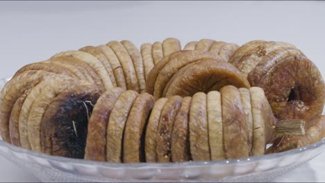 Hand-picking-up-dried-fig-from-plate-on-table