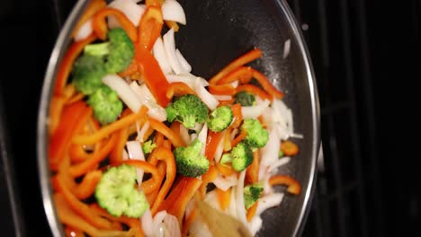 Static-vertical-shot---healthy-vegetables-cook-on-pan,-stir-with-wooden-spatula