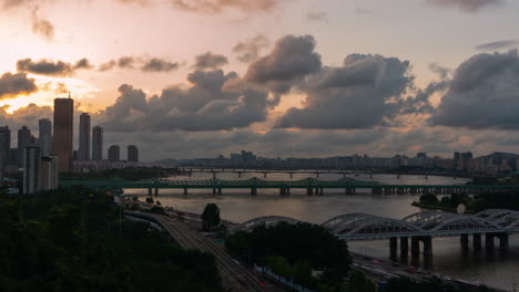 Beautiful-Dramatic-Sky-Sunset-Over-Han-River-Overlooking-Many-Bridges,-63-Building-and-Car-Traffic-Time-Lapse-on-Olympic-Expressway,-at-Yeouido-District-in-Seoul-City,-South-Korea---zoom-out