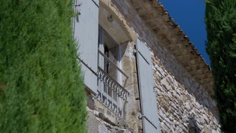 Slow-establishing-shot-of-a-chateau-window-with-wooden-shutters-under-sun