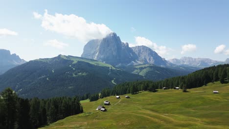 Wunderschöne-Grüne-Wiese-In-Den-Bergen-Mit-Blauem-Himmel-Und-Einem-Großen-Berg-Im-Hintergrund,-Dolomiten,-Italien,-Europa,-Drohne