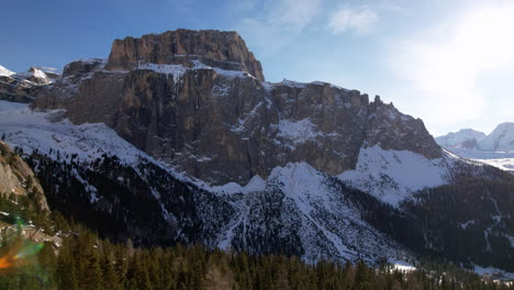 Ein-Atemberaubender-Blick-Auf-Eine-Schneebedeckte-Bergkette-Durch-Einen-Dichten-Kiefernwald,-Mit-Einem-Klaren-Blauen-Himmel-Darüber