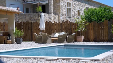 Slow-establishing-shot-of-pool-in-the-garden-of-a-stone-chateau-in-Uzes