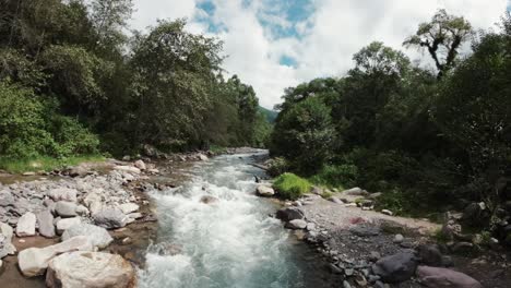 Eine-Herabstoßende-FPV-Drohne-Aus-Der-Luft-Folgt-Dem-Fluss-Flussaufwärts-Gegen-Die-Strömung-über-Der-Gischt