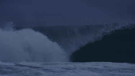 Una-Panorámica-Rápida-En-Cámara-Lenta-Sigue-El-Borde-De-Una-Ola-Que-Se-Estrella-Contra-La-Superficie-Del-Agua-Del-Océano-En-Un-Día-Tormentoso