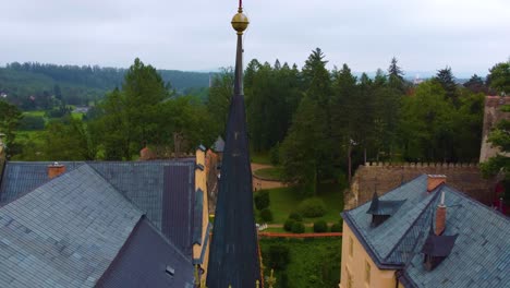 Aerial-view-of-Zruc-nad-Sazavou-Castle-reveals-a-medieval-fortress-amidst-lush-greenery-and-access-road-for-visitors