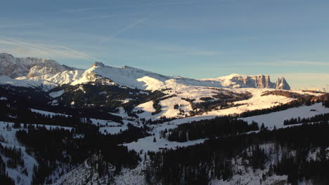 Atemberaubende-Luftaufnahme-Der-Dolomiten-Bei-Sonnenaufgang,-Wobei-Die-Schneebedeckten-Gipfel-Und-Täler-In-Warmes-Licht-Getaucht-Sind